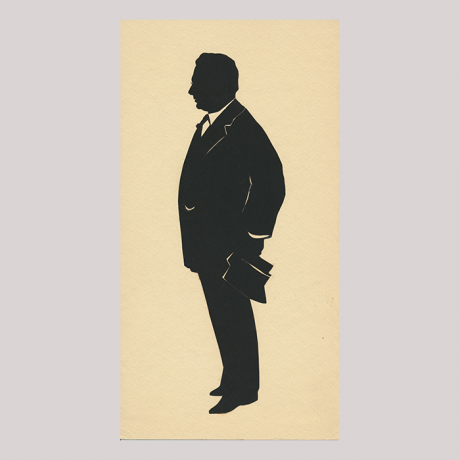 
        Front of silhouette, with man looking left, in suit with glasses.